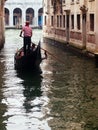 Gondolier ferrying tourists with its gondola in Venice