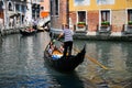 Gondolier navigating a gondola through canal