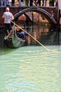 Gondolier navigating tourists in a Venice Canal