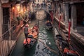 Gondolier rowing down a narrow canal in Venice, Italy Royalty Free Stock Photo