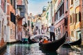 Gondolier rowing gondola on canal in Venice, Italy. Royalty Free Stock Photo