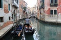 Gondolier with a rowing oar parking his gondola on a canal-street, Venice Royalty Free Stock Photo