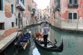 Gondolier with a rowing oar parking his gondola on a canal-street, Venice Royalty Free Stock Photo
