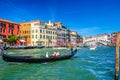 Gondolier and tourists on gondola traditional boat sailing on water of Grand Canal in Venice