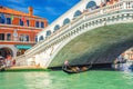 Gondolier and tourists on gondola traditional boat sailing on water of Grand Canal in Venice