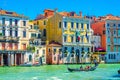 Gondolier and tourists on gondola traditional boat sailing on water of Grand Canal in Venice