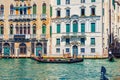 Gondolier and tourists on gondola traditional boat sailing on water of Grand Canal in Venice