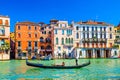 Gondolier and tourists on gondola traditional boat sailing on water of Grand Canal in Venice