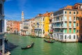 Gondolier and tourists on gondola traditional boat sailing on water of Grand Canal in Venice