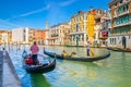 Gondolier and tourists on gondola traditional boat sailing on water of Grand Canal in Venice