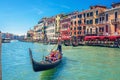 Gondolier and tourists on gondola traditional boat sailing on water of Grand Canal in Venice