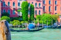 Gondolier and tourists on gondola traditional boat sailing on water of Grand Canal in Venice