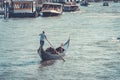 A gondolier or venetian boatman propelling a gondola on Grand Canal in Venice