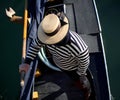 gondolier in Venice Italy with Venetian clothes and large straw hat while rowing on the gondola on the Grand Canal Royalty Free Stock Photo