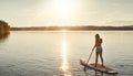 Gone paddling. an attractive young woman paddle boarding on a lake. Royalty Free Stock Photo