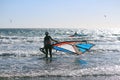 Gone surfing - Girl going windsurfing at the Atlantic ocean