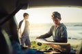 Gone surfing. two young brothers unloading their surfboards from the back of a car by the beach. Royalty Free Stock Photo