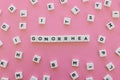 Gonorrhea word made of square letter word on pink background.