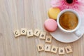 Good afternoon message coffee break concept  white cup of frothy espresso coffee with colourful French macaroons on wooden Royalty Free Stock Photo