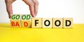 Good or bad food symbol. Doctor turns cubes and changes words `bad food` to `good food`. Beautiful yellow table, white backgro Royalty Free Stock Photo