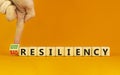 Good or bad resiliency symbol. Businessman turns a wooden cube, changes words bad resiliency to good resiliency. Beautiful orange