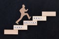 Good - Better - Best paper man climbing the steps to success in a conceptual image over black background Royalty Free Stock Photo