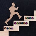 Good - Better - Best paper man climbing the steps to success in a conceptual image over black background Royalty Free Stock Photo