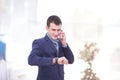 Good business talk. Handsome young man in formalwear talking on the phone and smiling while sitting at the office desk Royalty Free Stock Photo