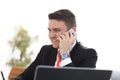 Good business talk. Handsome young man in formalwear talking on the phone and smiling while sitting