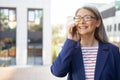 Good business talk. Portrait of cheerful mature business woman wearing eyeglasses and classic wear talking on mobile Royalty Free Stock Photo