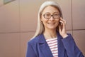 Good business talk. Portrait of a happy mature business woman wearing eyeglasses and classic wear talking on mobile Royalty Free Stock Photo