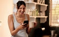 Good coffee and a good laugh makes a perfect morning. a young woman using a smartphone while enjoying a cup of coffee at Royalty Free Stock Photo