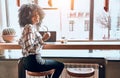Good day to work and study. Young beautiful african american woman sitting in a cafe at a laptop, looking at the camera and Royalty Free Stock Photo