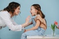 Good female doctor examining tonsils of a happy little girl. Side view Royalty Free Stock Photo