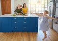 Good food makes for a happy family. a little girl dancing while her mother and grandmother cooks in the background.