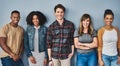 Good friends stand together. Studio portrait of a diverse group of young people standing together against a gray Royalty Free Stock Photo