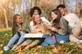 Good friends talking, laughing, eating pizza while picnic at park Royalty Free Stock Photo