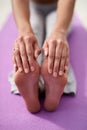 Good health is made up of small goals. a young woman touching her toes while practicing yoga outside on a sunny day.