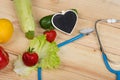 Good healthy and diet concept - Blackboard in shape of heart, stethoscope and vegetables, fruits and berries Royalty Free Stock Photo