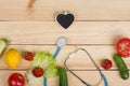 Good healthy and diet concept - Blackboard in shape of heart, stethoscope and vegetables, fruits and berries Royalty Free Stock Photo