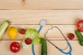 Good healthy and diet concept - stethoscope and vegetables, fruits and berries on table