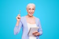 Good idea Gray haired old cheerful happy smiling business woman wearing glasses, holding paper note book and pen Royalty Free Stock Photo