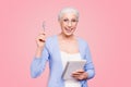 Good idea Gray haired old cheerful happy smiling business woman wearing glasses, holding paper note book and pen Royalty Free Stock Photo