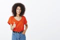 Good job, girl. Confident pleased attractive woman with afro hairstyle, holding hand in pocket and showing thumbs up