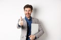 Good job. Happy smiling business man in suit holding laptop, showing thumb up to praise you, nice work gesture, standing Royalty Free Stock Photo