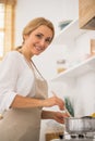 Good-lloking blonde woman cooking in the kitchen