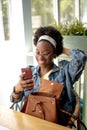 African american woman with frizzy dark hair, doing selfie, smiling at camera