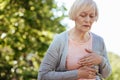 Good looking aged woman having heart attack outdoors