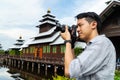 Good looking Asian photographer man taking photo at the Nepal pagoda tourist attraction