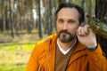 Good-looking bearded man standing near tree in forest